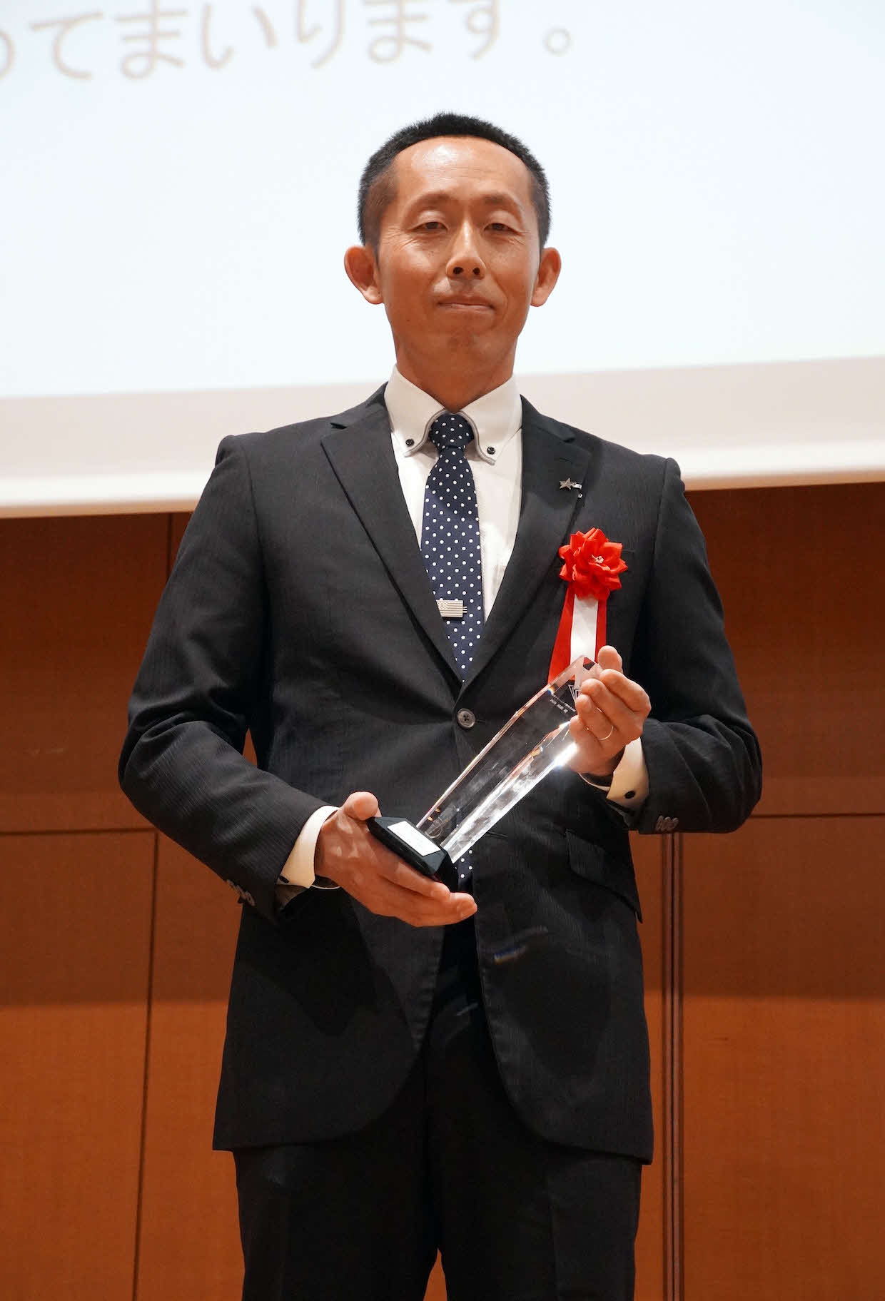 都内で行われた授与式で「2025年度　優秀トレーニング指導者表彰」のトロフィーを持つDeNA四角純哉氏（球団提供）