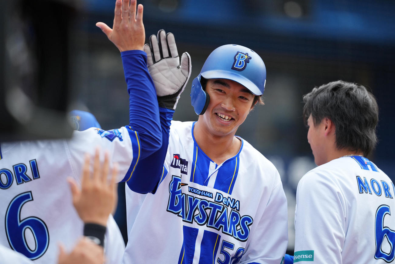 DeNA対ヤクルト　8回裏DeNA2死一、二塁、佐野の適時二塁打で生還しナインの出迎えを受ける梶原（撮影・垰建太）