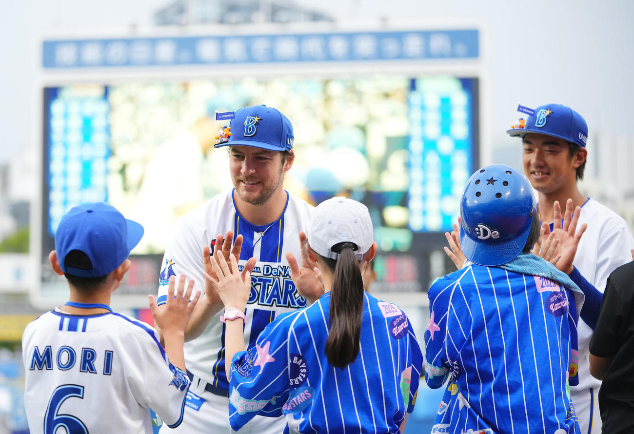 DeNA対ヤクルト　ヤクルトに勝利しファンの子どもとタッチを交わすDeNAバウアー（左）と梶原（撮影・垰建太）
