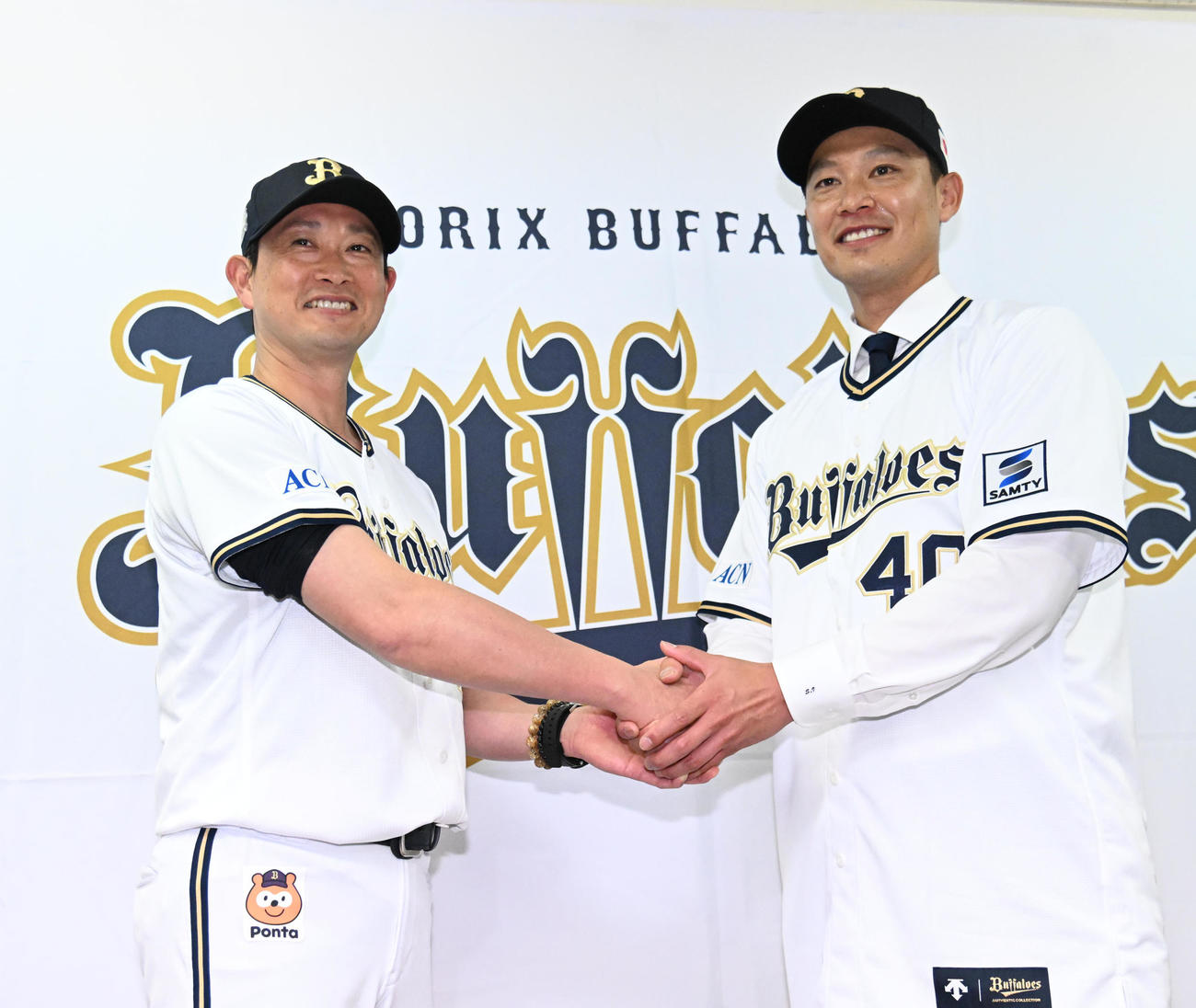 入団会見で岸田監督（左）と握手をする岩崎（撮影・石井愛子）