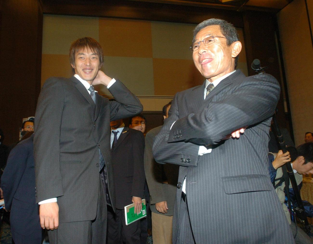 オリックス・バファローズ結団式　仰木彬監督（右）から「後でゆっくり話そう」と声をかけられ照れたような困ったような表情を浮かべる岩隈久志（2004年11月10日撮影）
