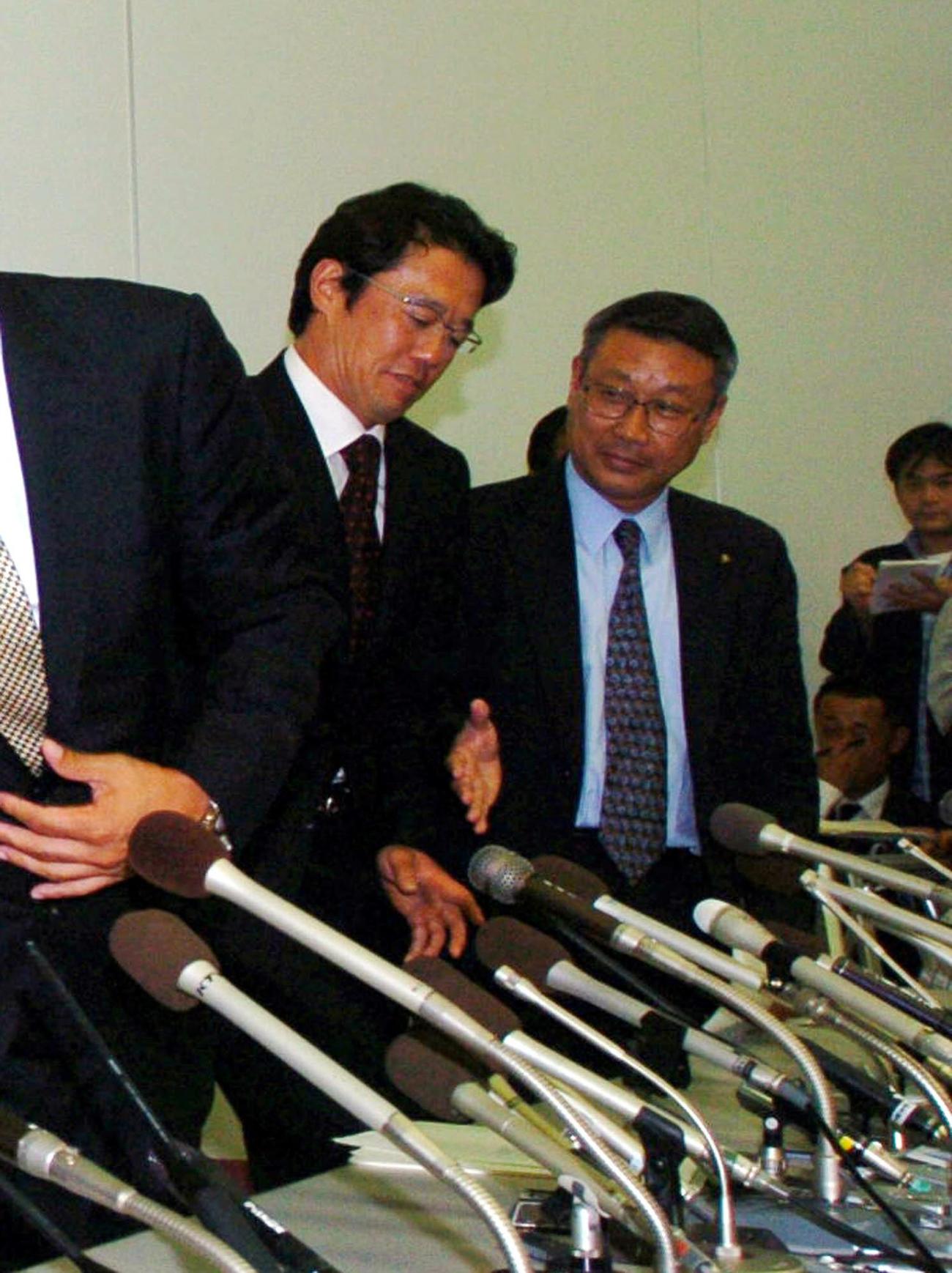 協議・交渉委員会を終えスト回避の会見終了後、経営者側代表として出席したロッテの瀬戸山隆三球団代表（右）に握手を求められたものの、応じずに退席する古田敦也会長（2004年9月10日撮影）