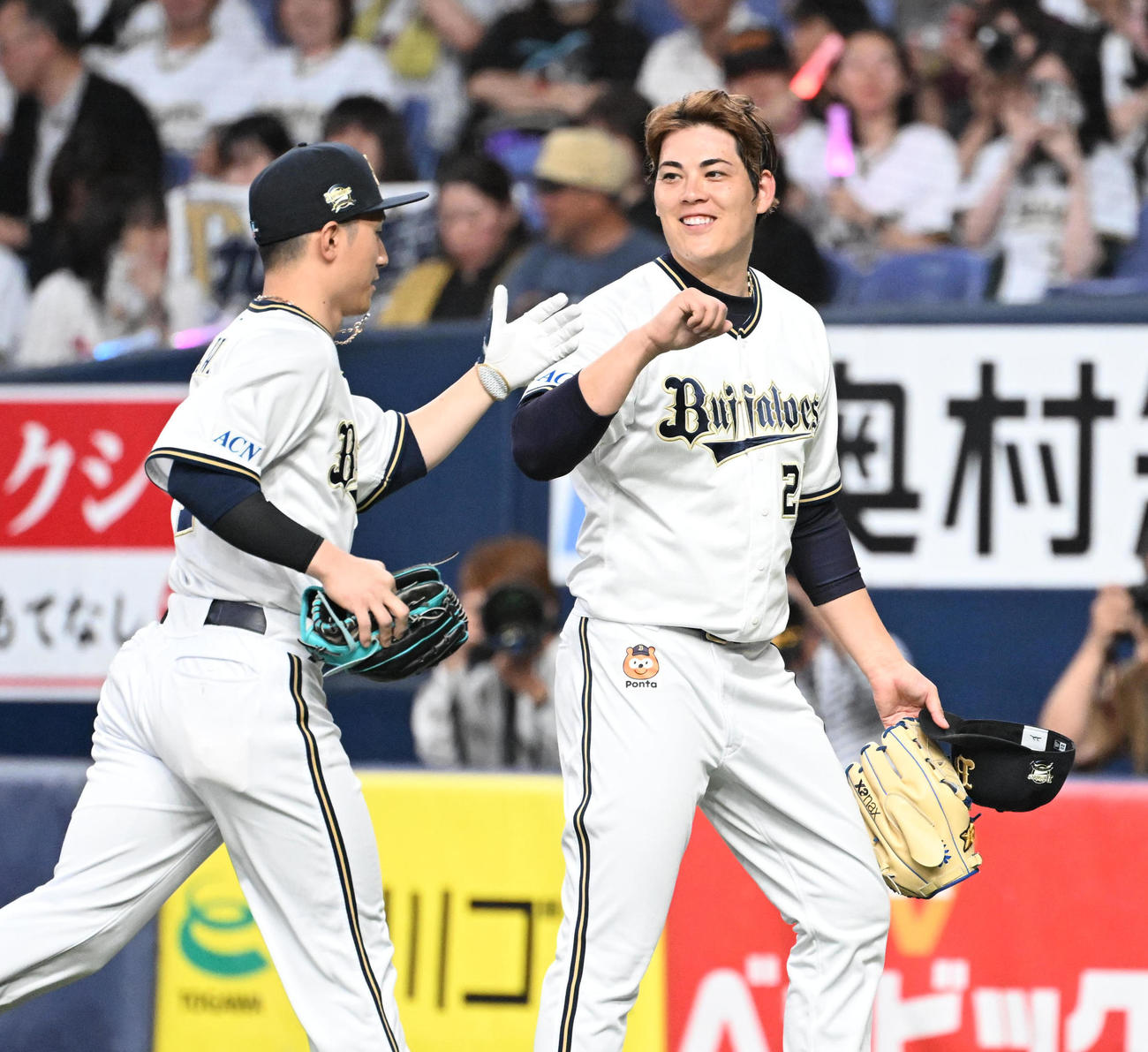 オリックス西川龍馬（左）とタッチする九里亜蓮