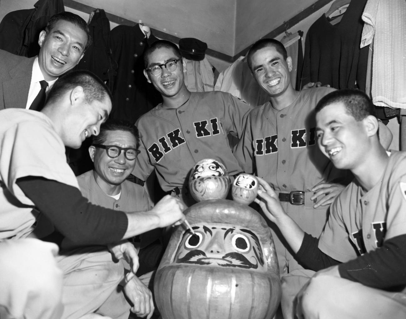 立大合宿所・智徳寮でダルマに目を入れる、左から長嶋茂雄三塁手、辻猛監督（50歳）、杉浦忠投手、主将の本屋敷錦吾遊撃手、浅井精一外野手