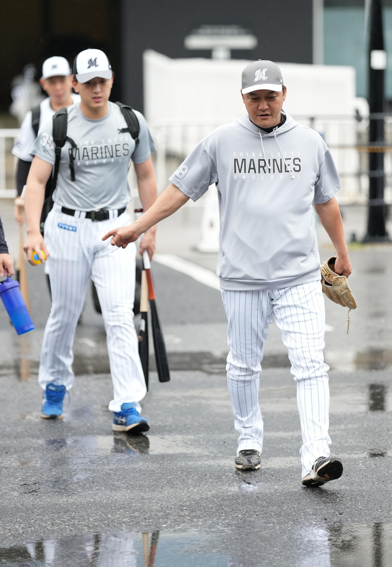 ロッテ対巨人　室内練習場に向かうロッテ金子チーフ守備走塁コーチ（右）（撮影・鈴木みどり）