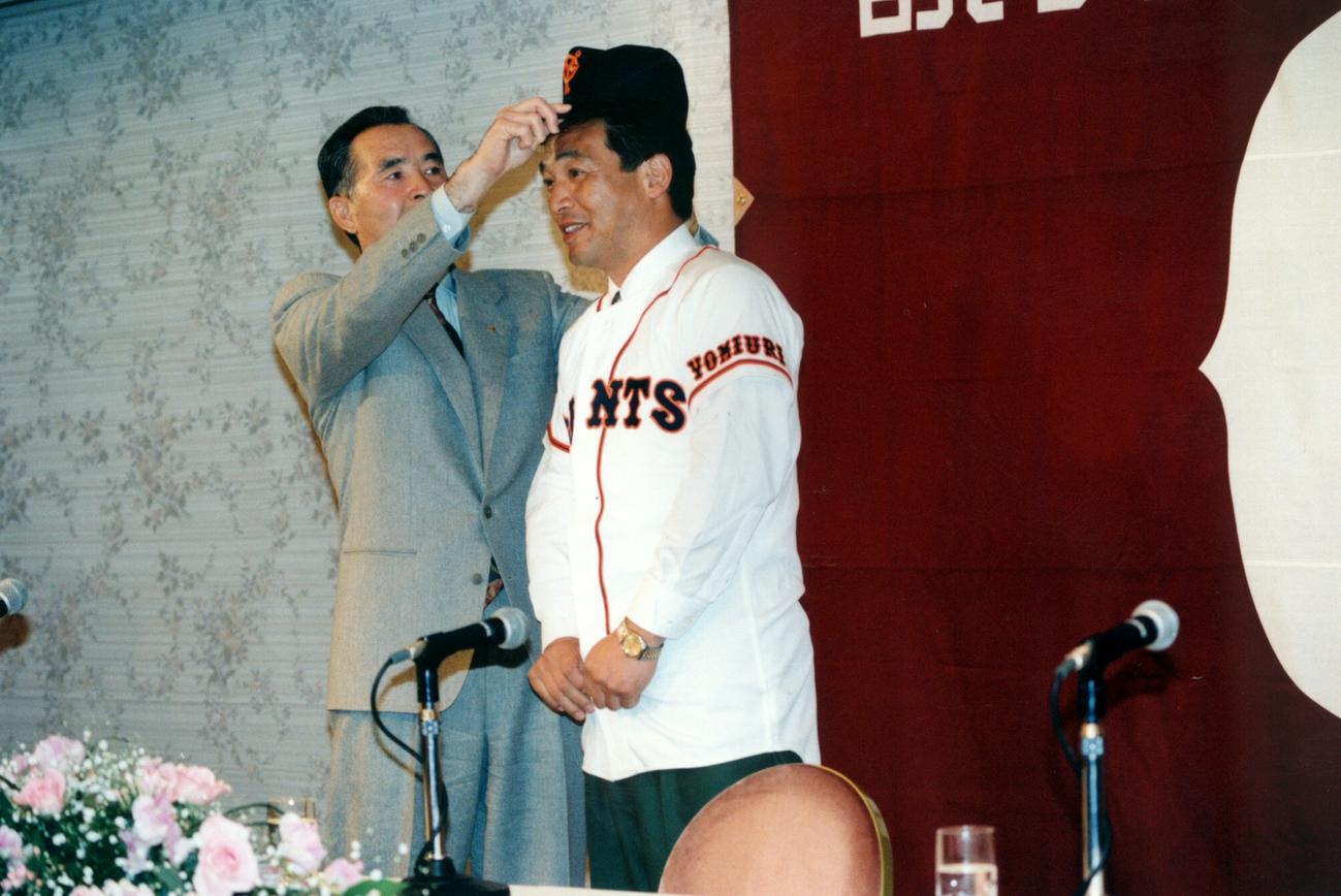 FA制で巨人入りした落合博満(右）に帽子をかぶせる長嶋茂雄監督（1993年12月21日）