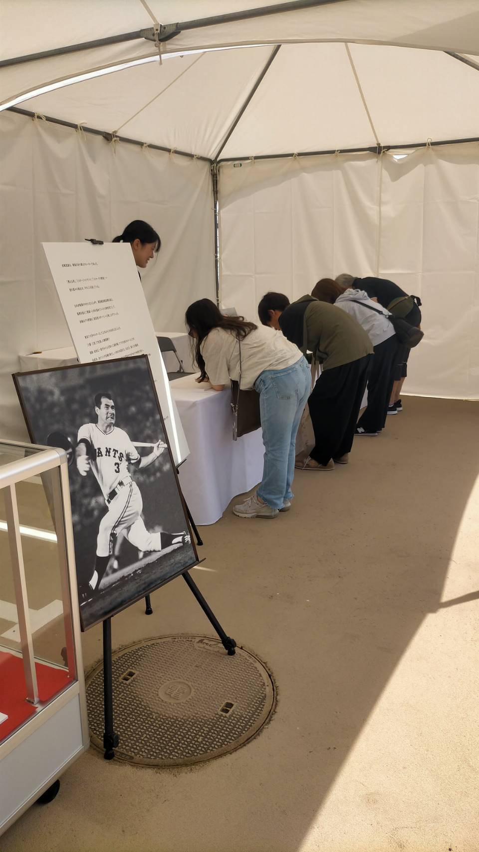 写真も飾られた追悼記帳所に並ぶファン