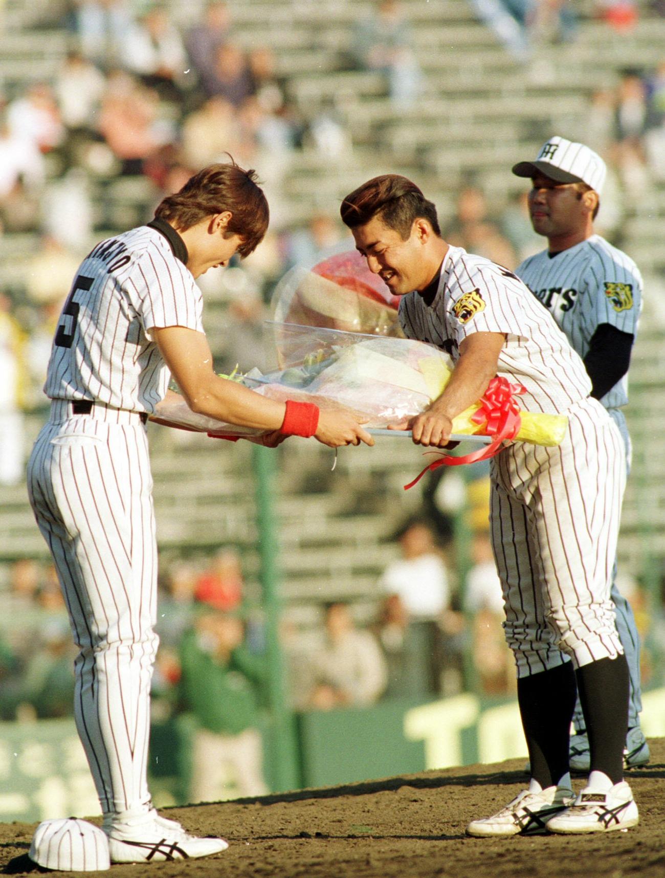 97年10月、阪神対横浜　引退試合で新庄剛志（左）から花束受ける亀山努