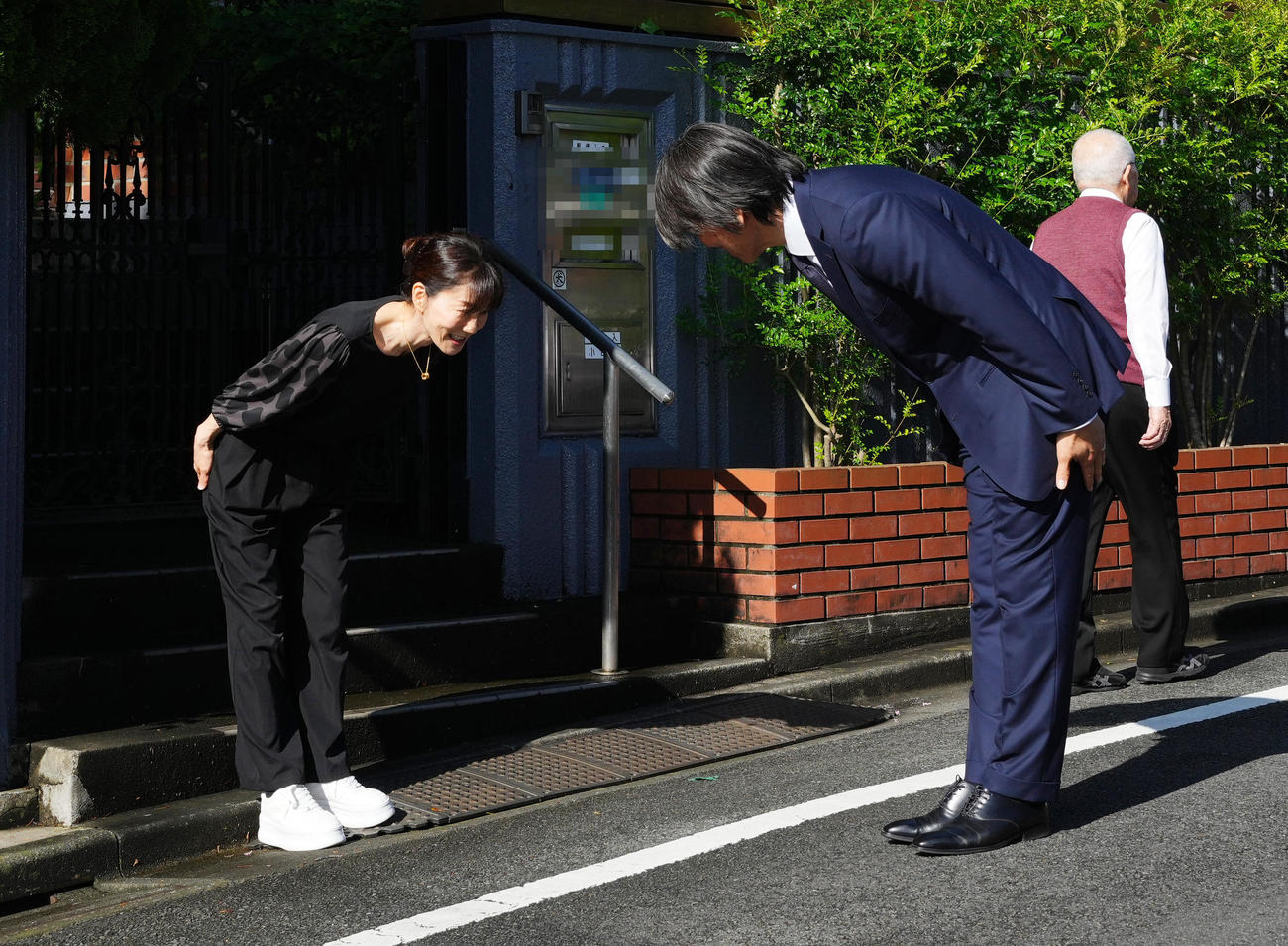帰国し弔問に訪れた松井氏は、長島三奈さん（左）に見送られ引き揚げる（撮影・菅敏）