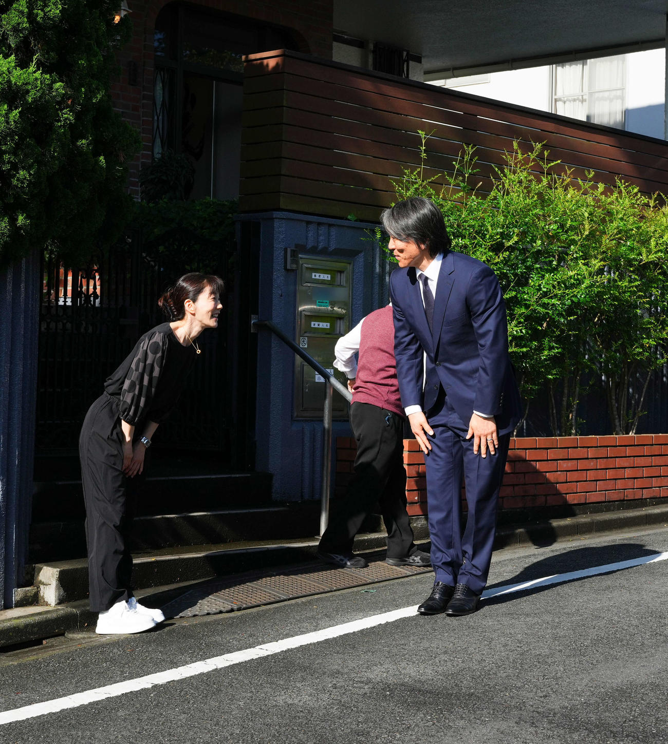 帰国し弔問に訪れた松井氏は、長島三奈さん（左）に見送られ引き揚げる（写真は一部加工）