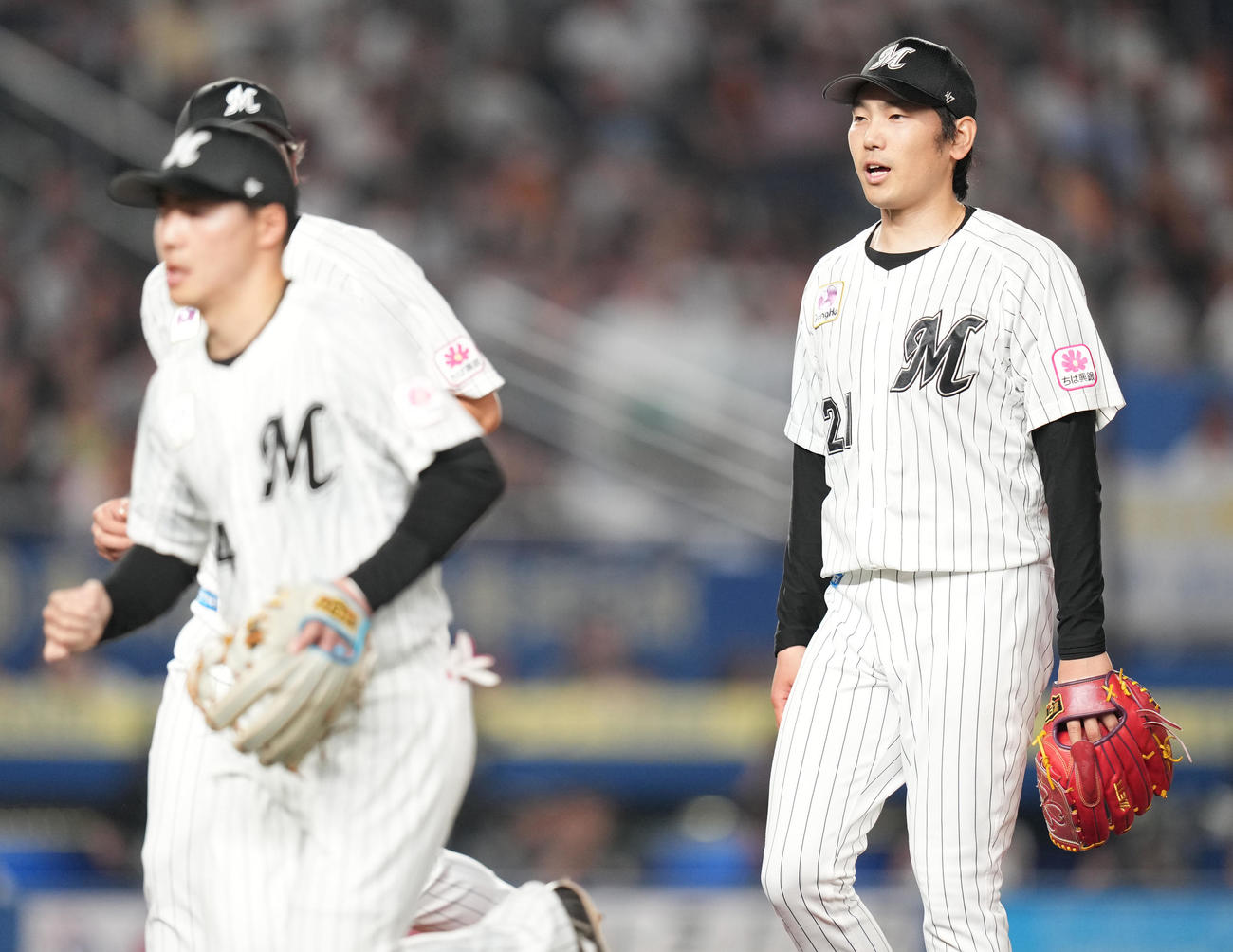 ロッテ対巨人　7回表までに抑え、ナインに声をかけながらベンチへ戻るロッテ石川柊（右）（撮影・鈴木みどり）