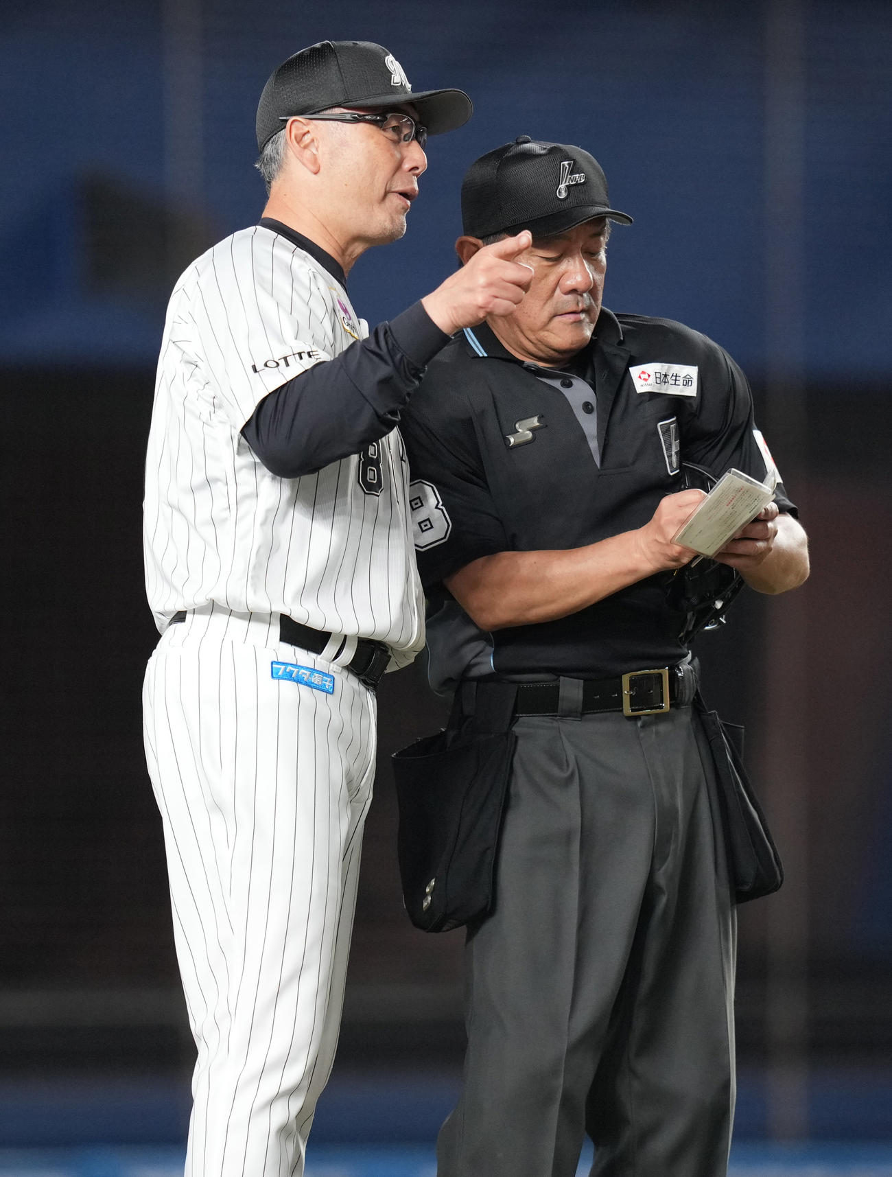 ロッテ対巨人　8回表前、先発石川柊の降板を告げるロッテ吉井監督（左）（撮影・鈴木みどり）