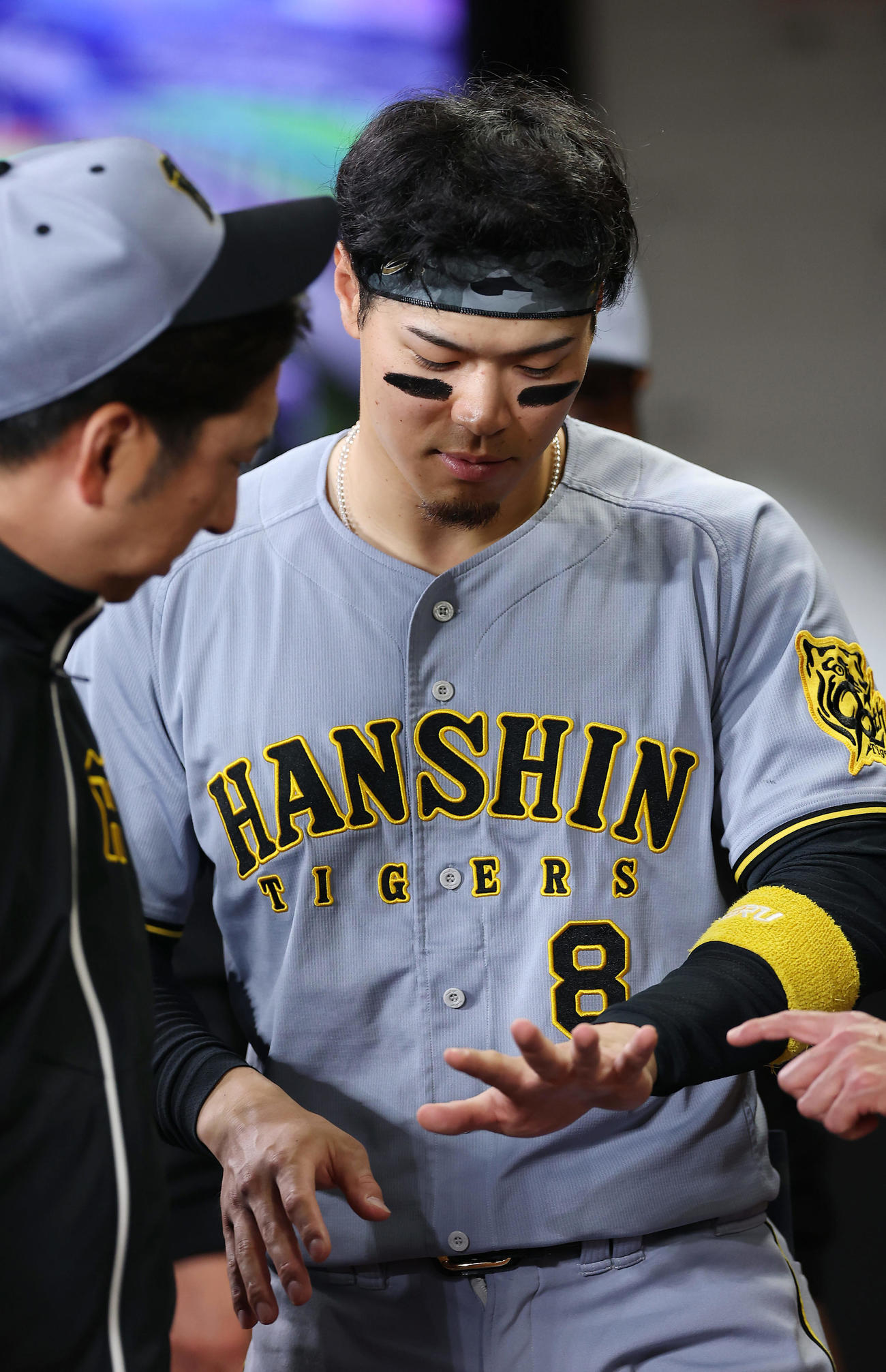 日本ハム対阪神　4回表の攻撃終了後、ベンチで阪神藤川監督（左）に左手を見せる佐藤輝（撮影・前田充）