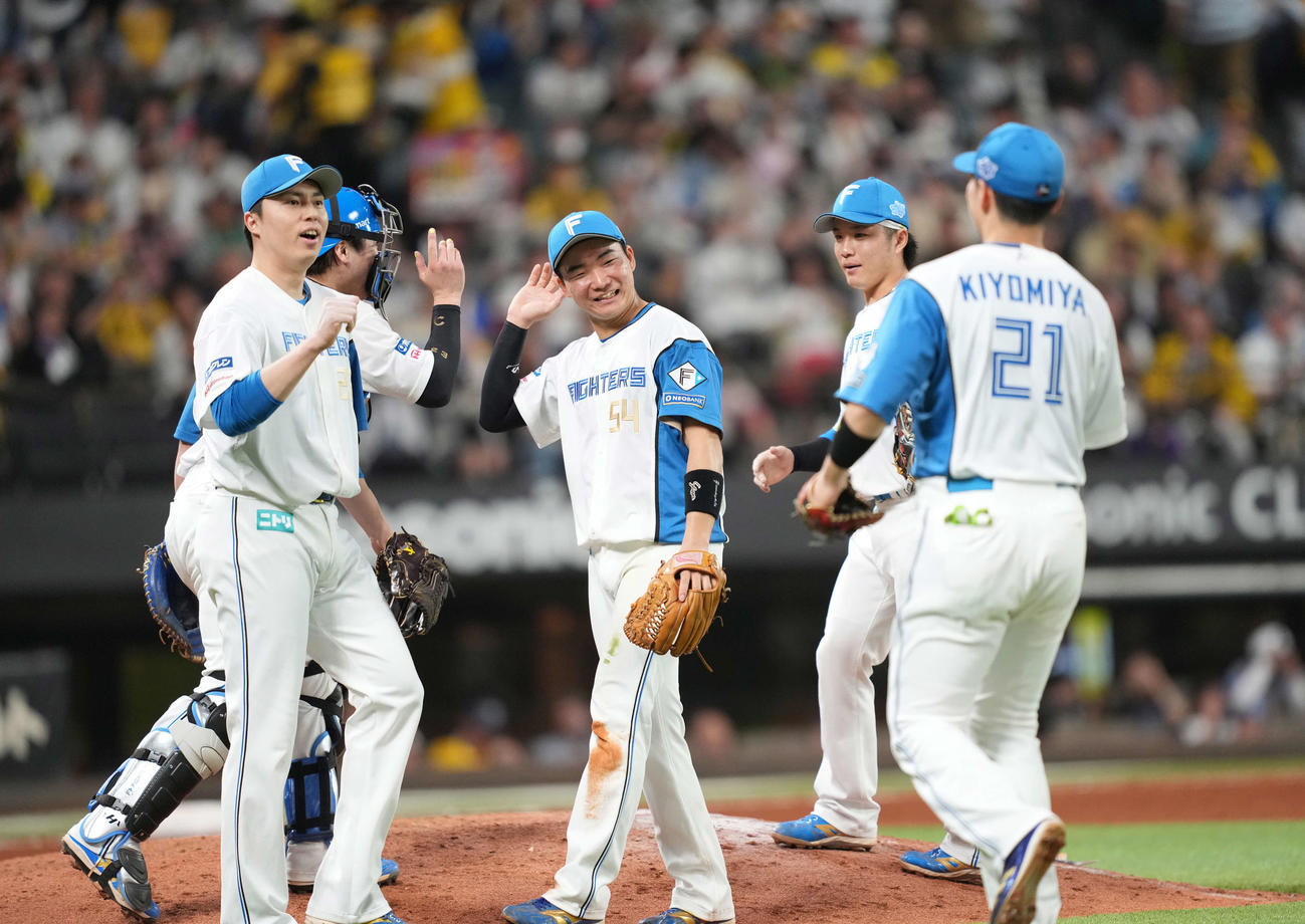 日本ハム対阪神　笑顔でハイタッチをかわす山県（中央）ら日本ハムナイン（撮影・井上学）