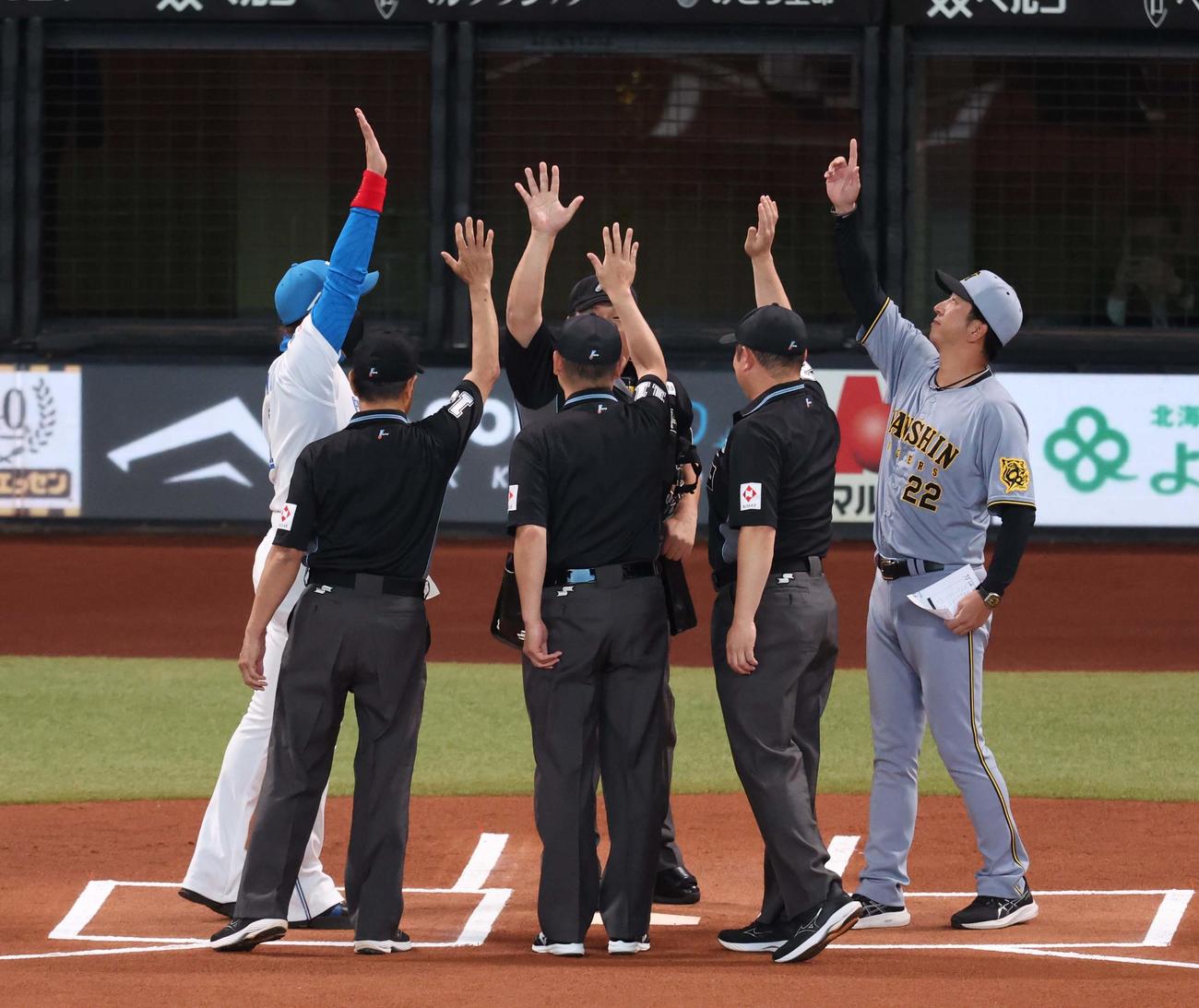 日本ハム対阪神　メンバー表で手を合わせる両監督と審判団（撮影・黒川智章）