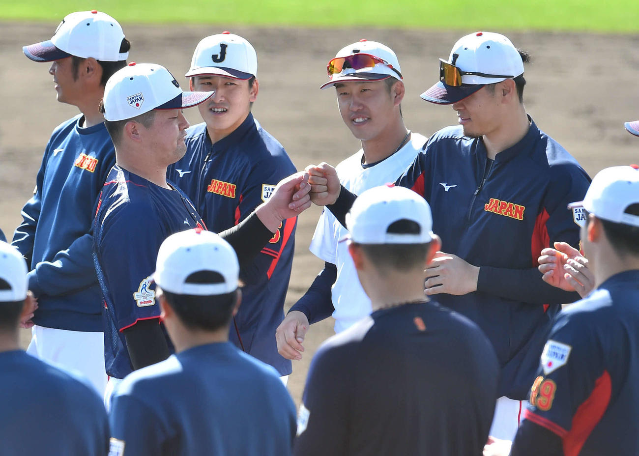 23年11月、侍ジャパン宮崎秋季キャンプ最終日、手締めの音頭を務めた牧（左から2人目）とグータッチを交わす佐藤輝