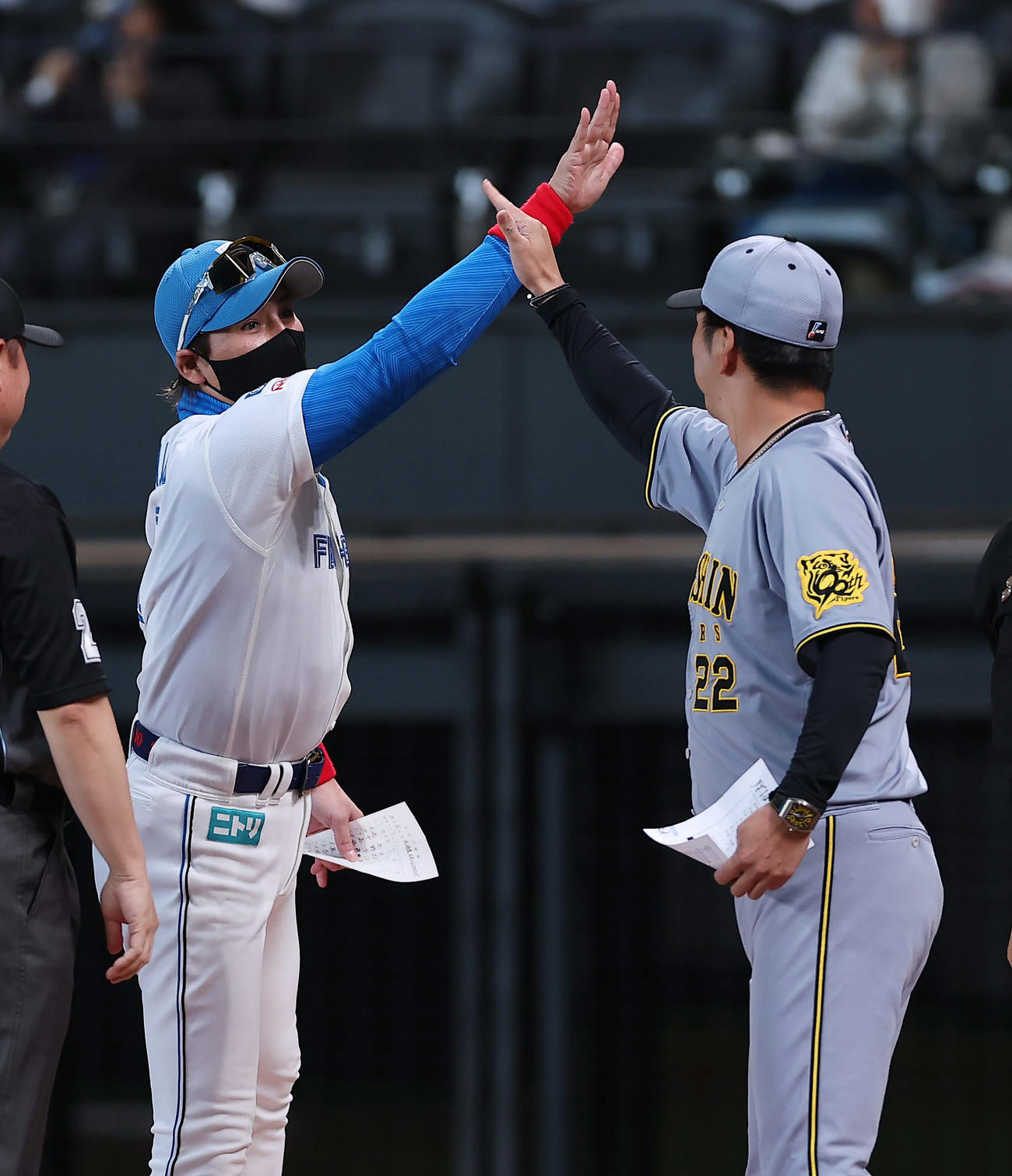 日本ハム対阪神　試合前のメンバー表交換でハイタッチを交わす日本ハム新庄監督（左）と阪神藤川監督（撮影・前田充）
