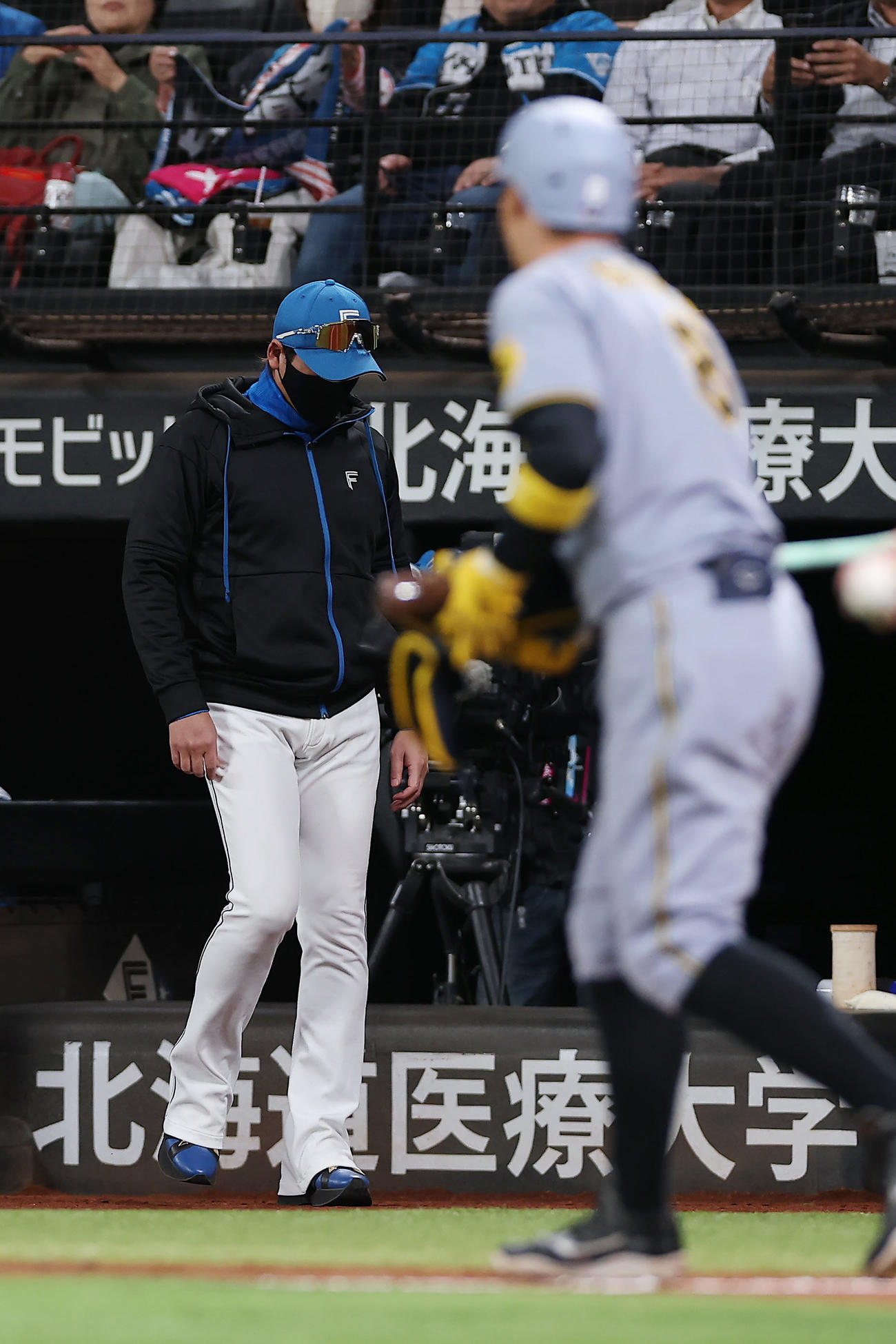 日本ハム対阪神　5回表阪神1死一、二塁、投手交代を告げるためベンチを出る新庄監督。右は四球を選んだ佐藤輝（撮影・前田充）