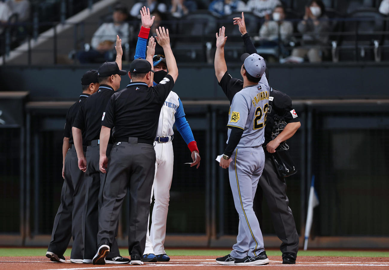 日本ハム対阪神　試合前のメンバー表交換で手を合わせる日本ハム新庄監督と阪神藤川監督と審判団（撮影・前田充）