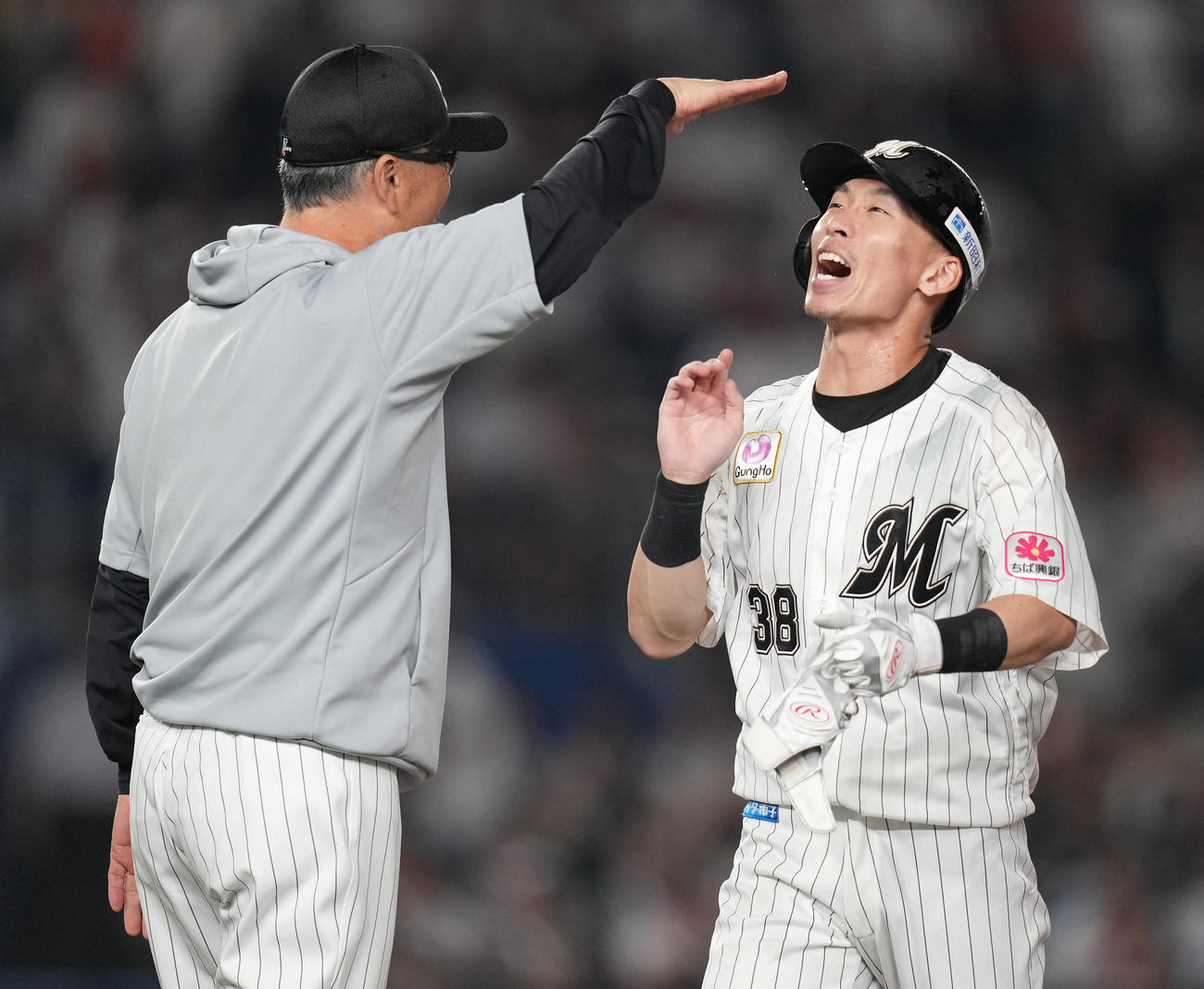 ロッテ対巨人　10回裏ロッテ2死満塁、押し出し死球を受けサヨナラ勝ちし、吉井監督（左）とタッチを交わす高部（撮影・鈴木みどり）