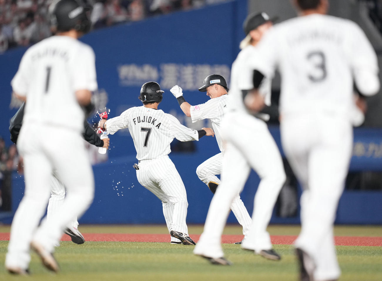 ロッテ対巨人　10回裏ロッテ2死満塁、押し出し死球を受けサヨナラ勝ちし、水をかけられないよう逃げまくる高部（中央右）（撮影・鈴木みどり）
