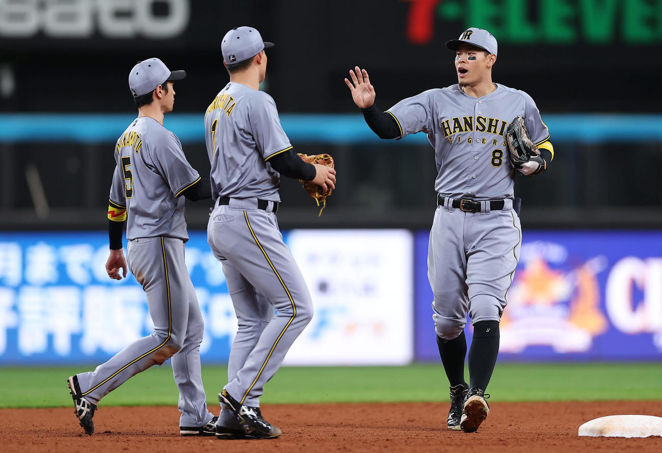 日本ハム対阪神　日本ハムに勝利し近本（左）、森下（中央）とタッチを交わす阪神佐藤輝（撮影・前田充）