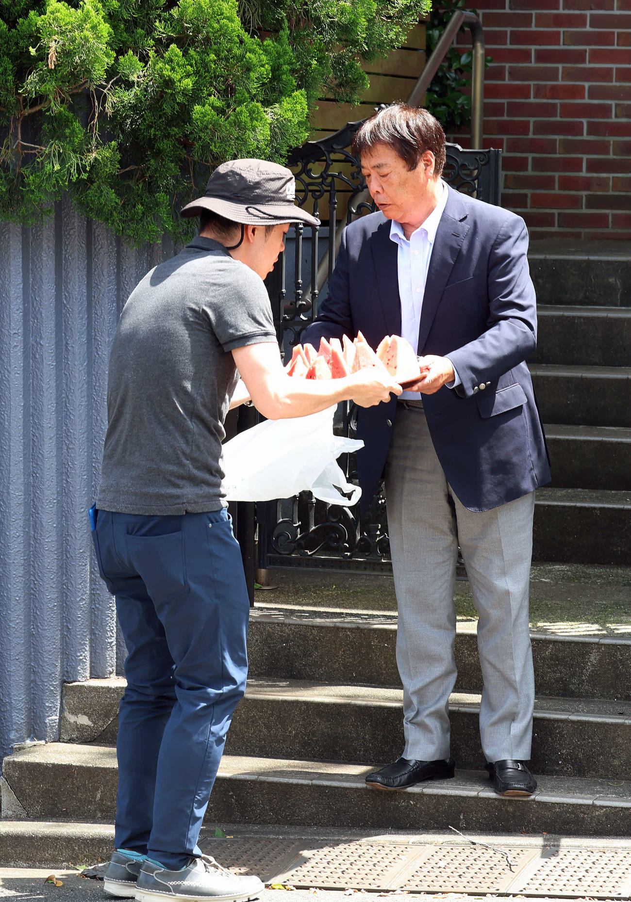 長嶋茂雄さんの専属広報を務めた小俣進さんから報道陣にすいかが配られた（撮影・山本朝陽）