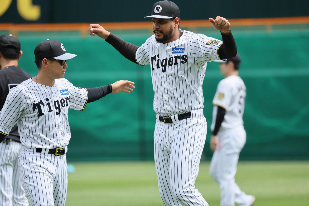 阪神対オリックス　試合前、阪神ヘルナンデス（右）は糸原の案内で湘南乃風の若旦那にタオルをもらいに行く（撮影・宮崎幸一）