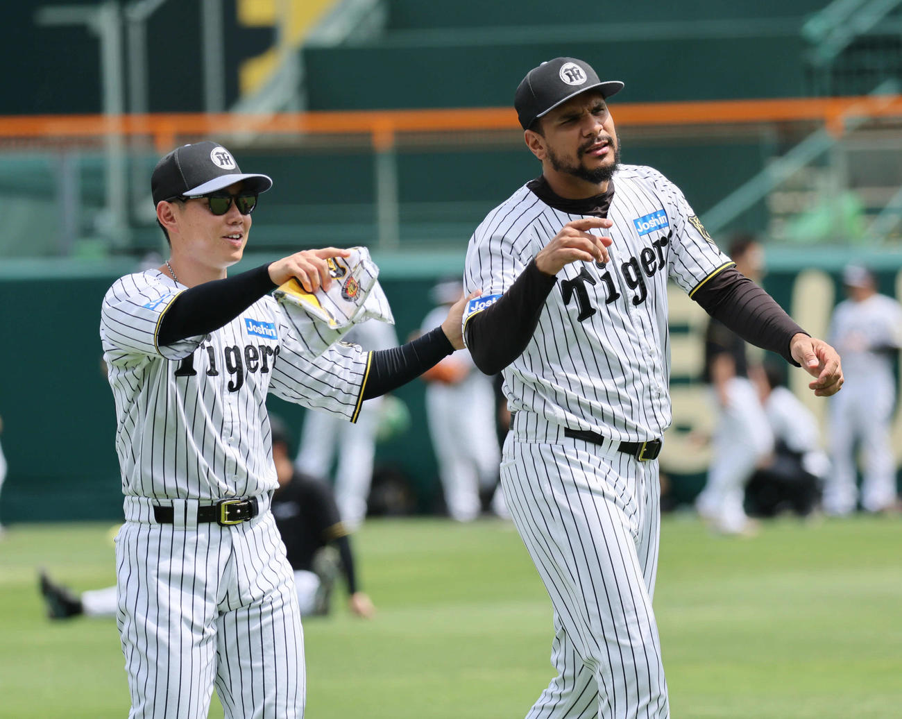阪神対オリックス　試合前、阪神ヘルナンデス（右）は糸原の案内で湘南乃風の若旦那にタオルをもらいに行く（撮影・宮崎幸一）