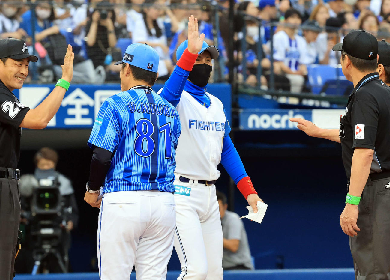 DeNA対日本ハム　メンバー最終確認でDeNA三浦監督（手前）らとハイタッチであいさつする日本ハム新庄監督（撮影・浅見桂子）