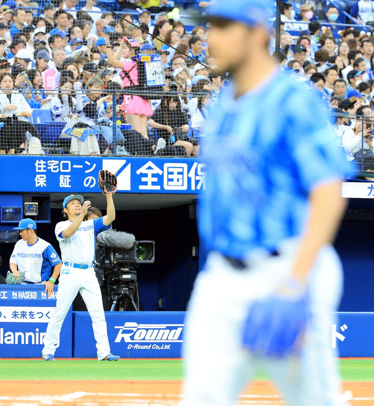 DeNA対日本ハム　1回表日本ハムの攻撃を抑えたバウアー（手前）の奥でマウンドに向かう伊藤（撮影・浅見桂子）