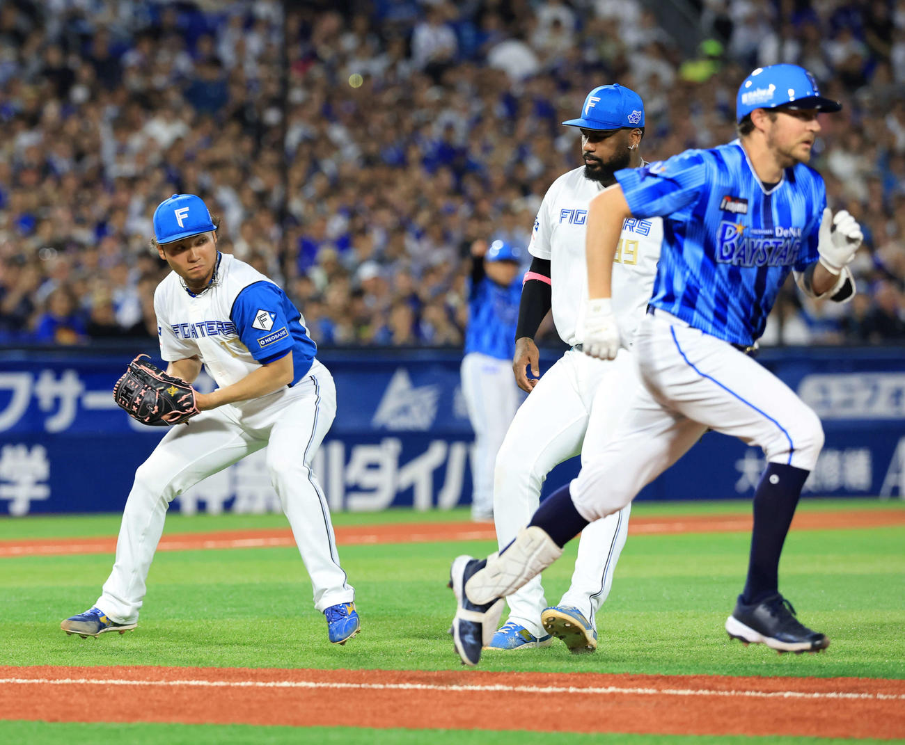 DeNA対日本ハム　4回裏DeNA1死二塁、バウアー（右）が送りバントを決め捕球する伊藤（撮影・浅見桂子）