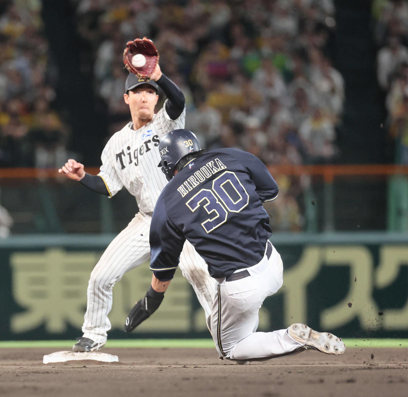 阪神対オリックス　9回表オリックス無死一塁、西川の二塁への打球で併殺を狙った小幡は、広岡のスライディングで一塁へ送球できず。リプレイ検証で守備妨害が認められる（撮影・宮崎幸一）