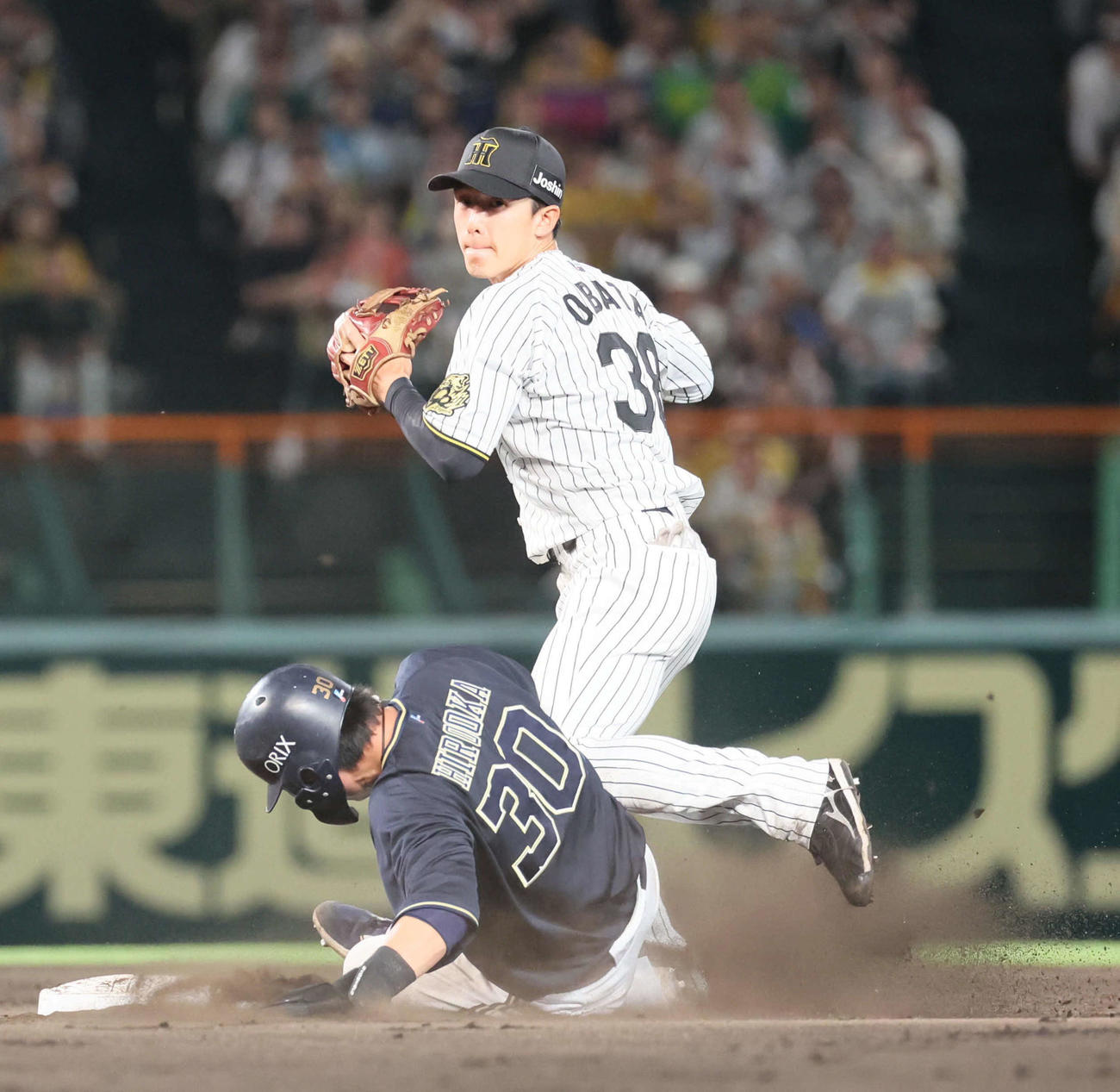 阪神対オリックス　9回表オリックス無死一塁、西川の二塁への打球で併殺を狙った小幡は、広岡のスライディングで一塁へ送球できず。リプレイ検証で守備妨害が認められる（撮影・宮崎幸一）