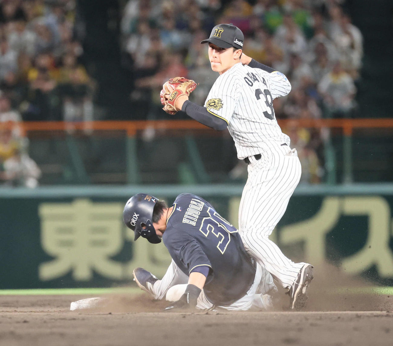阪神対オリックス　9回表オリックス無死一塁、西川の二塁への打球で併殺を狙った小幡は、広岡のスライディングで一塁へ送球できず。リプレイ検証で守備妨害が認められる（撮影・宮崎幸一）