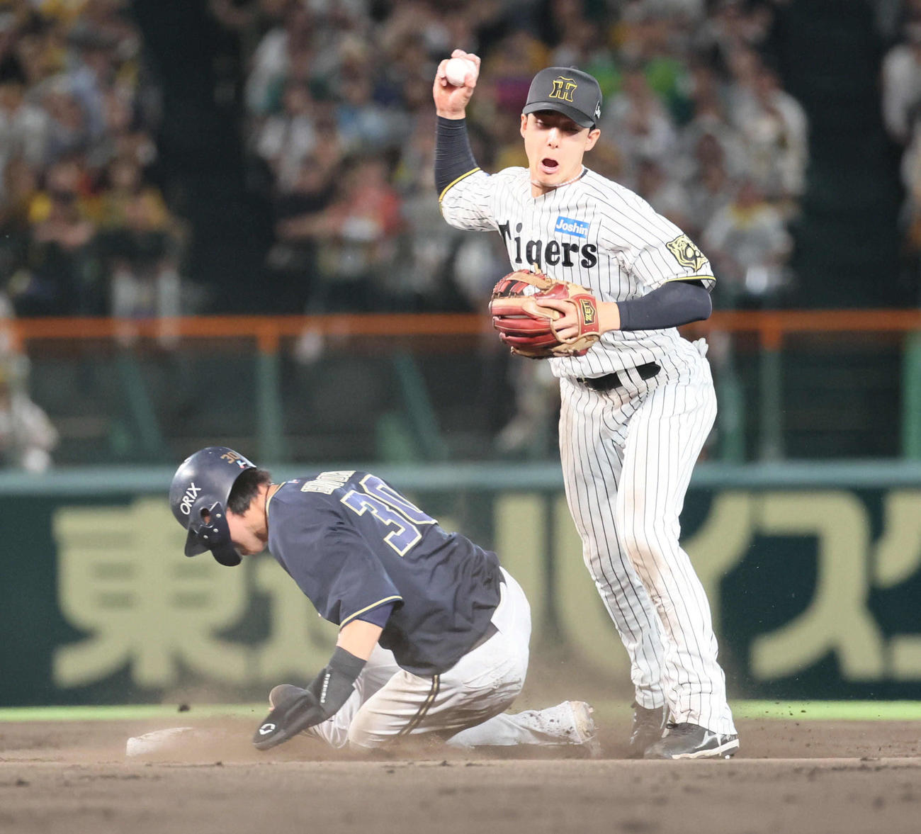 阪神対オリックス　9回表オリックス無死一塁、西川の二塁への打球で併殺を狙った小幡は、広岡のスライディングで一塁へ送球できず。リプレイ検証で守備妨害が認められる（撮影・宮崎幸一）