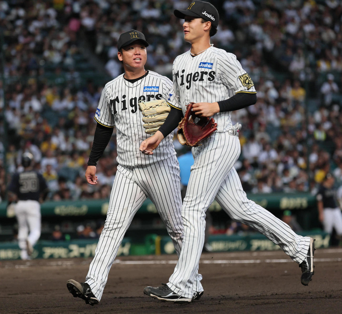 阪神対オリックス　3回表オリックス攻撃終了、村上（左）は好守を見せた小幡を迎える（撮影・宮崎幸一）