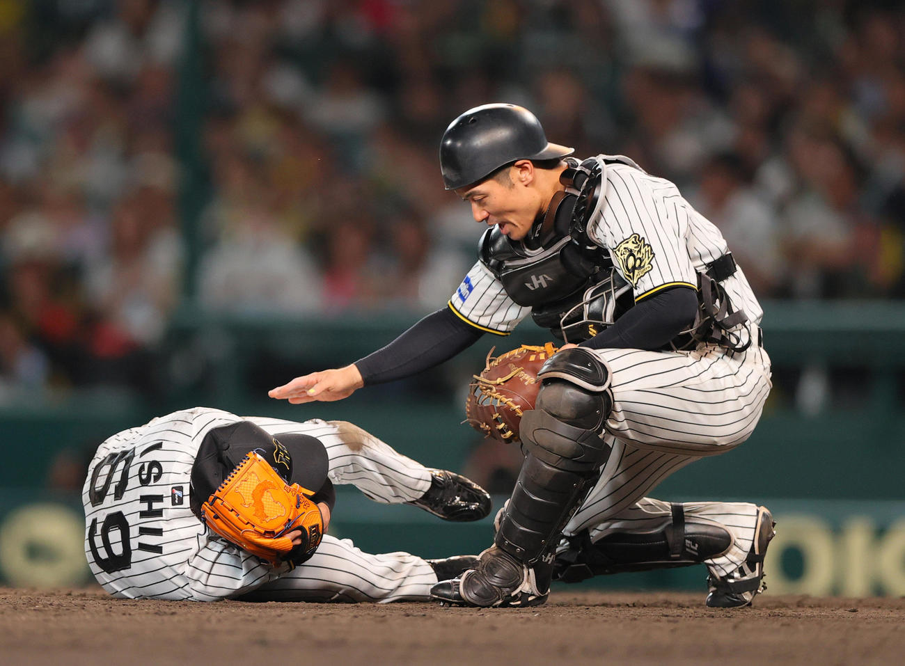 阪神対オリックス　9回表オリックス無死、捕手坂本（右）は広岡の打球が頭部に当たった石井の元に駆けつける（撮影・上山淳一）