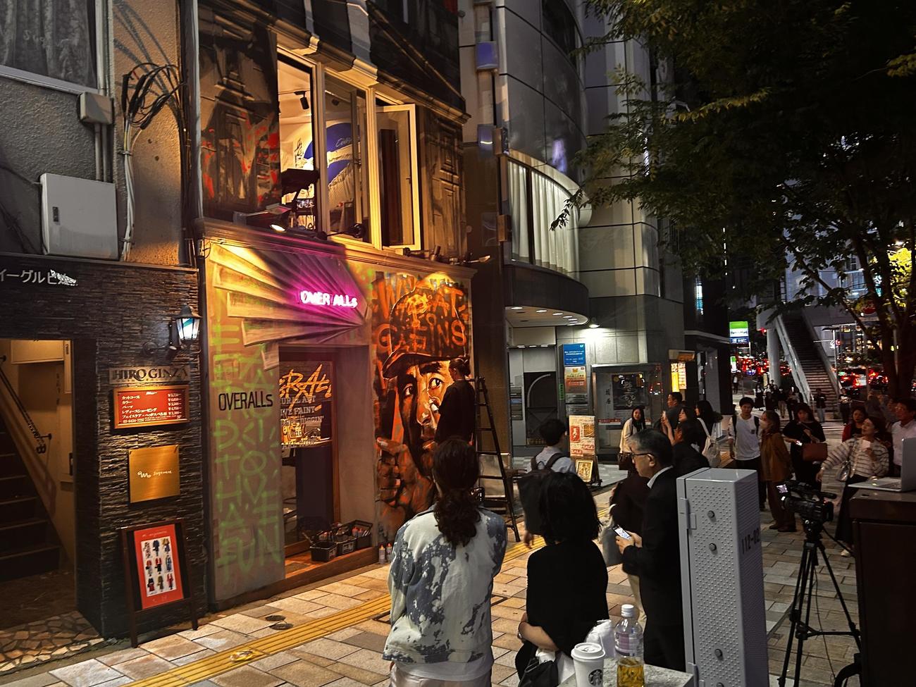 外苑駅前の「OVER ALLs」のオフィスの外壁に描かれる故長嶋茂雄さん。製作中には道行く人たちが足を止めた（撮影・平山連）