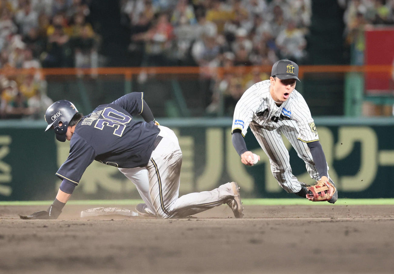 阪神対オリックス　9回表オリックス無死一塁、西川の二塁への打球で併殺を狙った小幡は、広岡のスライディングで一塁へ送球できず。リプレイ検証で守備妨害が認められる（撮影・宮崎幸一）