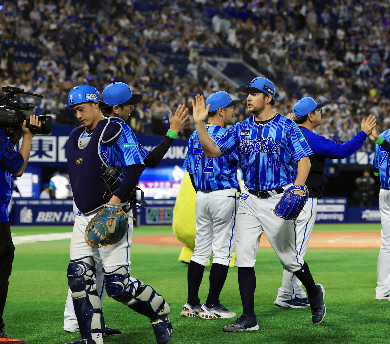 DeNA対日本ハム　9回完投勝利を決めたDeNAバウアー（右）は三浦監督とハイタッチ。手前は松尾（撮影・浅見桂子）