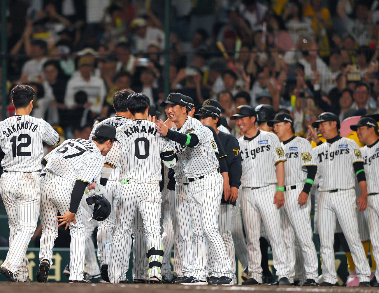 阪神対オリックス　10回裏阪神1死満塁、サヨナラ右前適時打を放った木浪（手前）を笑顔で出迎える藤川監督（撮影・上山淳一）