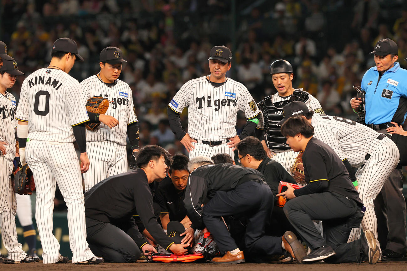 阪神対オリックス　9回表オリックス無死、広岡の打球が頭部に当たった石井（下）を心配そうに見つめる藤川監督（中央）（撮影・上山淳一）