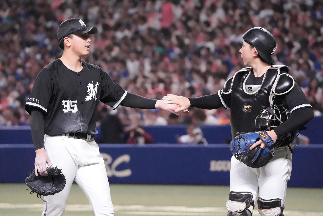 中日対ロッテ　1回終了、寺地（右）とタッチを交わしベンチへ戻る田中晴（撮影・森本幸一）