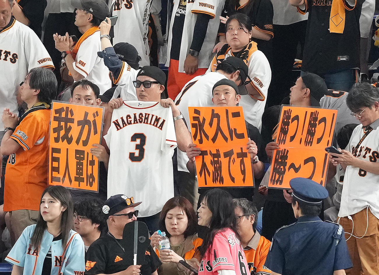 巨人対楽天　楽天に勝利し、長嶋さんの名言のボードを手に勝利を喜ぶ巨人ファン（撮影・足立雅史）