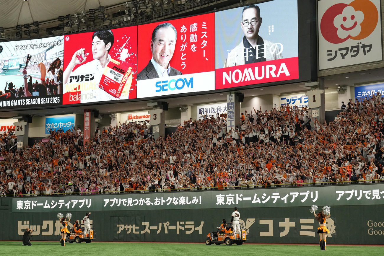 巨人対楽天　長嶋さんのセコムの電子広告看板の下、勝利を喜ぶ巨人ファン（撮影・足立雅史）