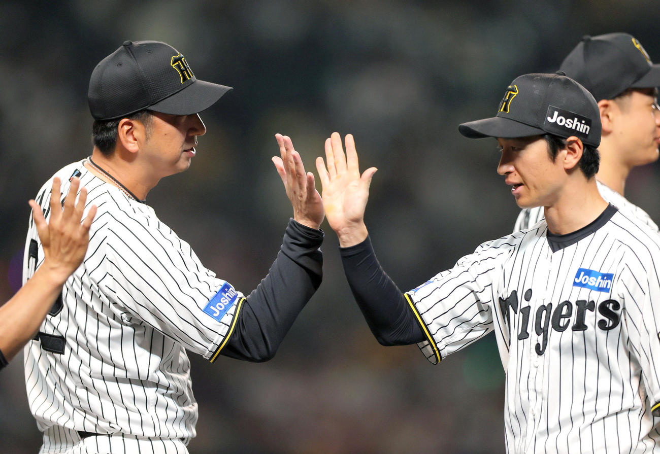 阪神対オリックス　オリックスに勝利した藤川監督（左）はベンチ前で近本とタッチをかわす（撮影・上山淳一）
