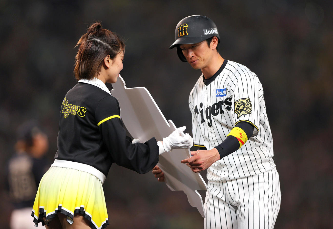 阪神対オリックス　7回裏阪神2死一、二塁、近本は右適時二塁打を放ち1000本安打を記録し記念ボードを受け取る（撮影・上山淳一）
