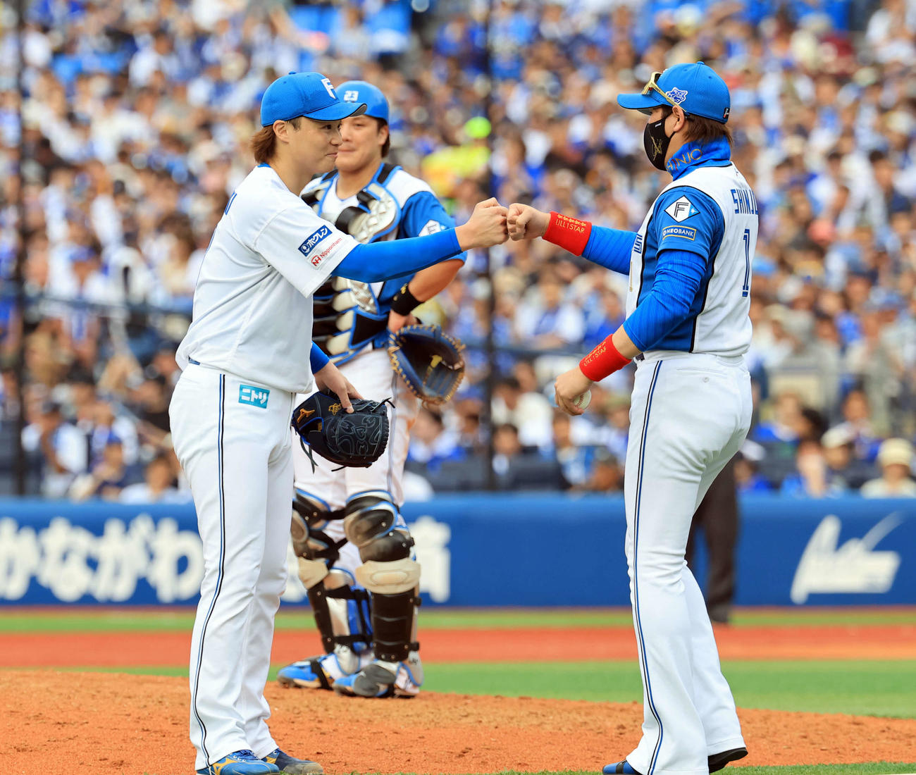 DeNA対日本ハム　8回裏DeNA2死の場面で降板となった山崎（左）は新庄監督とグータッチ（撮影・浅見桂子）