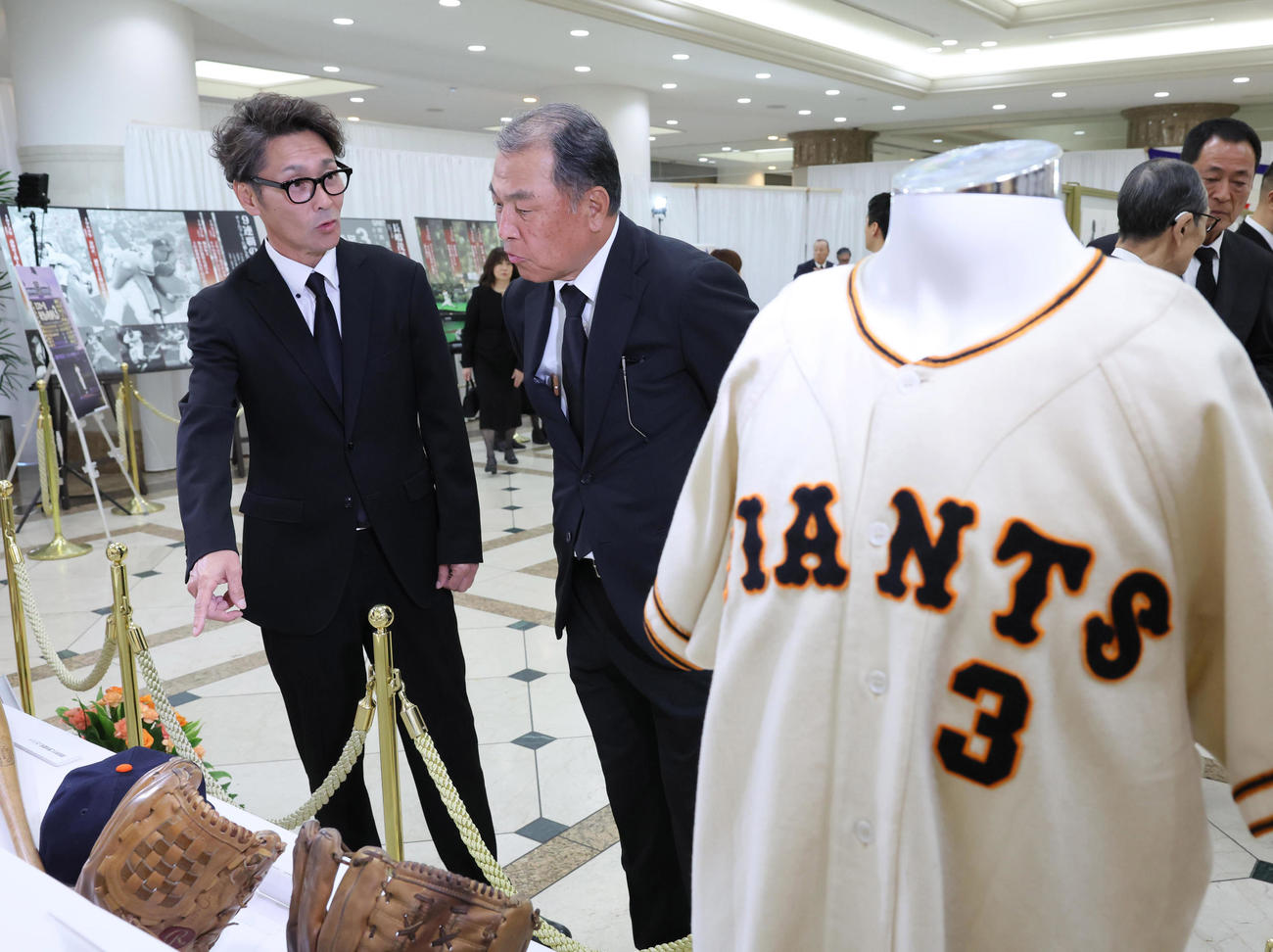 長嶋さんの通夜・告別式の会場に設けられたゆかりの品を見る元木さん（左）、村田さんら（読売新聞社提供）